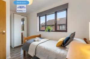 a bedroom with a bed and two windows at 2BR Flat By Azzurri Properties Short Lets & Serviced Accommodation Canary Wharf With Open Garden, Free Parking & Short Stays in London