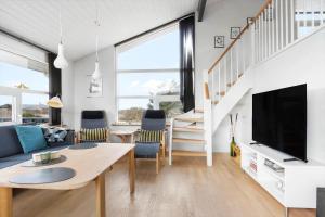 een woonkamer met een bank en een tv bij LN1906-Hjorring-Under-Bjergene-5 in Hjørring