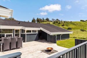 een houten terras met stoelen en een huis bij LN1906-Hjorring-Under-Bjergene-5 in Hjørring