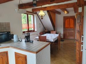 une cuisine et une salle à manger avec une table et une table et des chaises dans l'établissement Romantic Hideaway & Remote Work Haven pet friendly, à Neuve-Église