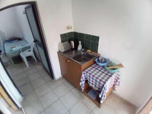 a small kitchen with a sink and a table at Hydrovor Apartment & Room in Hamallë