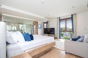 Un dormitorio con una gran cama blanca y un televisor. en Penthouse Skyline-Top floor 4 bedroom sea view pool apartment, en Ban Bang Khu