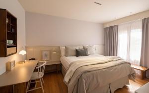 a bedroom with a large bed and a desk at Kau Yatún Hotel Boutique in El Calafate