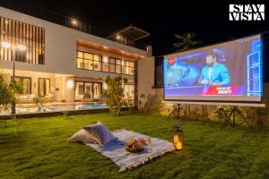 a large screen in the yard of a house at StayVista at The Amaryllis with Heated Pool & Projector Set-Up in Karjat