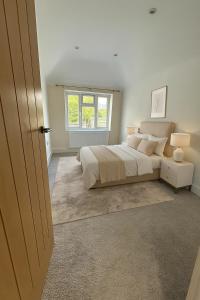 a bedroom with a large bed and a window at Modern Luxury 6 Bed Harrow in Hatch End