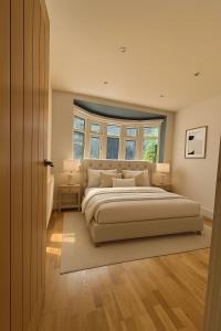 a bedroom with a large bed and a window at Modern Luxury 6 Bed Harrow in Hatch End +2 photos