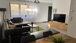 a living room with a couch and a flat screen tv at FeWo Souterrain TT-Bodensee in Tettnang