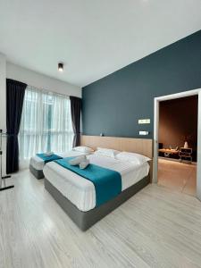 a bedroom with two beds and a blue wall at Sutera Avenue Opposite Imago Shopping Mall KK in Kota Kinabalu