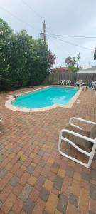 a swimming pool with two lounge chairs next to it at Beach & Palms condo condo in South Padre Island