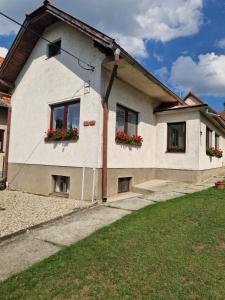 a house with two windows with flower boxes on it at Orlik in Spišské Bystré