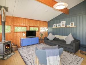a living room with a couch and a stove at Blue Pine Lodge in Embo