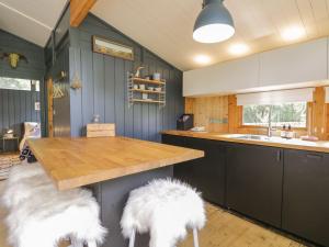 a kitchen with two white furry stools at a counter at Blue Pine Lodge in Embo +7 photos