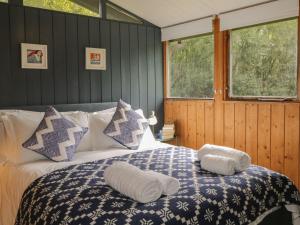 a bedroom with a bed with two towels on it at Blue Pine Lodge in Embo