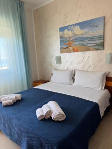 a bedroom with a bed with towels on it at Hotel Germania in Praia a Mare