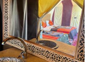 einen Spiegel in einem Zimmer mit einem Bett in der Unterkunft luxury desert night camp in Merzouga