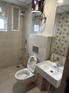 a bathroom with a toilet and a sink at Highlands Haven by Havenly stays in Zirakpur