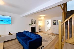 a living room with a blue couch and a fireplace at Cosy Mumbles Escape Fun & Relax in The Mumbles