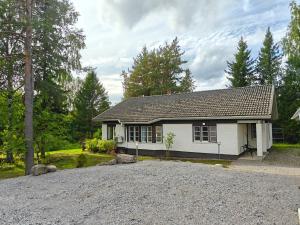 a small white house with a gravel driveway at Kodikas talo lammen rannalla in Raahe