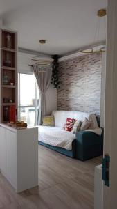 une chambre avec un lit et un mur de briques dans l'établissement Ocean View JJ, à Mongaguá
