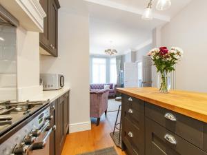 a kitchen with a counter with a vase of flowers at Star Of The Sea in Broadstairs +22 photos