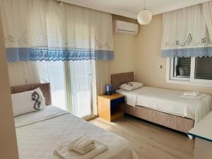 アラカティにあるEvalacati - Villa Harnup- Tamamen Müstakil Villaのベッドが2つと窓がある小さな部屋 +47枚の写真
