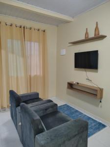 een woonkamer met een bank en een flatscreen-tv bij Seu lar fora de casa in Belém