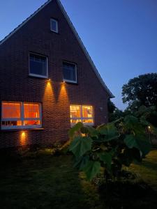 a brick house with lights on the windows at night at Knut's Nest in Westoverledingen