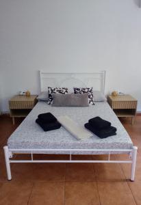 Una cama blanca con dos almohadas encima. en Oikia, en Nauplia