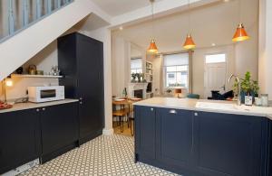 eine Küche mit Spüle und Mikrowelle in der Unterkunft Lockwood Cottage, Close to Monk Bar, sleeps 4 in York