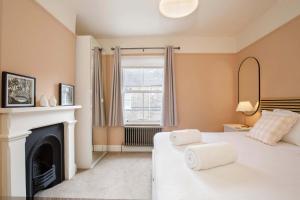 ein Schlafzimmer mit zwei Betten und einem Kamin in der Unterkunft Lockwood Cottage, Close to Monk Bar, sleeps 4 in York