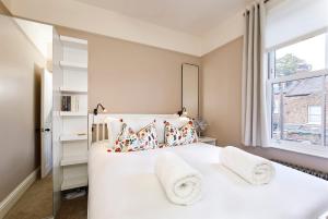 ein Schlafzimmer mit einem weißen Bett und einem Fenster in der Unterkunft Lockwood Cottage, Close to Monk Bar, sleeps 4 in York