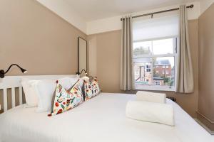 ein Schlafzimmer mit einem weißen Bett mit Kissen und einem Fenster in der Unterkunft Lockwood Cottage, Close to Monk Bar, sleeps 4 in York + 15 Fotos
