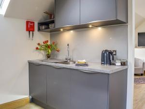 a kitchen with gray cabinets and a counter top at The Old Mill in Fettercairn