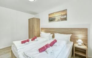 a bedroom with two white beds with red pillows at Nice Apartment In Altenkirchen in Altenkirchen