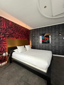 Una cama o camas en una habitación de LOGIS Hôtel Borel