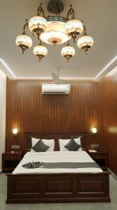 a bedroom with a large bed and a chandelier at Hotel Devaan in Kālānwāli