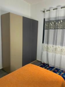 Un dormitorio con una cama y una cortina. en Maison d'hôtes Jaxaay, en Keur Massar