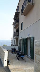a patio with tables and benches on the side of a building at Rooms Anđelka in Bol