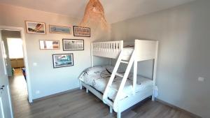 Un dormitorio infantil con una litera y cuadros en la pared. en Sea-scape - De Panne - spacieux appartement très bien situé avec vue sur mer, en De Panne