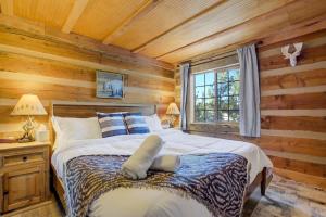 a bedroom with a bed in a log cabin at Cave Cabin Hot Tub Fire Pit MTN Experience in Florissant
