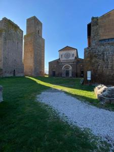 an old castle with two towers and a grass field at Alloggio turistico a casa di Gió in Tuscania +6 photos