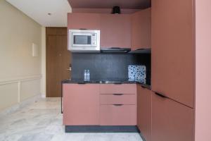 a kitchen with pink cabinets and a microwave at Beautiful Studio in Oasis - Gym access & Balcony & Free Parking & Wifi Fiber in Casablanca