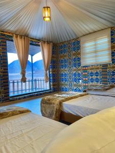 a bedroom with two beds in a room with a window at Wadi Rum Star Camp in Wadi Rum