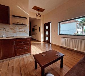 a living room with a table and a kitchen at Petroula Suites Pozar in Kato Loutraki