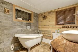 a bathroom with a tub and a sink at Come to the Hideout Hot Tub Fire Pits & Views in Divide