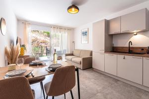 una cucina e un soggiorno con tavolo e sedie di L'Île de Beauté - Climatisé a Agnarelu
