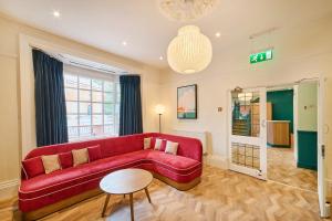 a living room with a red couch and a table at Garner Hotel Birmingham South East by IHG in Birmingham