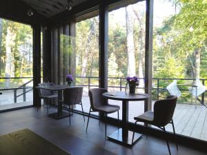 a room with two tables and chairs and a large window at Albatross Apartment Sea in Ķesterciems