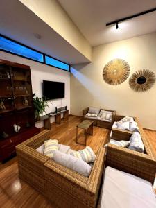 un salon avec des canapés et une télévision à écran plat dans l'établissement Casa Greemat 2Habs con AC, piscina a pasos de la playa, à Zorritos