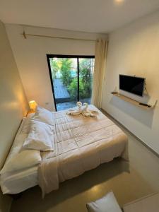 une chambre avec un grand lit et une télévision dans l'établissement Casa Greemat 2Habs con AC, piscina a pasos de la playa, à Zorritos 33 autres photos